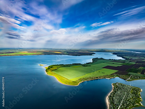 aerial view over peninsula covered with green grass at costesti reservoir at duruitoarea village on the north of moldova during morning with lue sky