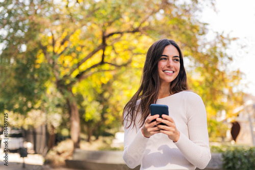caucasian woman smiling happy using her mobile phone, concept of technology of communication and modern lifestyle, copy space for text