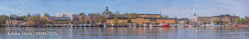 Panorama with mooring sail ships in the bay Ladugårdslandsviken, the island Skeppsholmen with old maritime buildings, a sunny summer morning in Stockholm