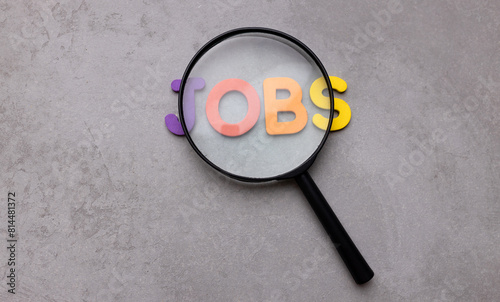 Magnifying glass and the word Jobs. The concept of job search and new employees for a vacancy. Human resources and labor market