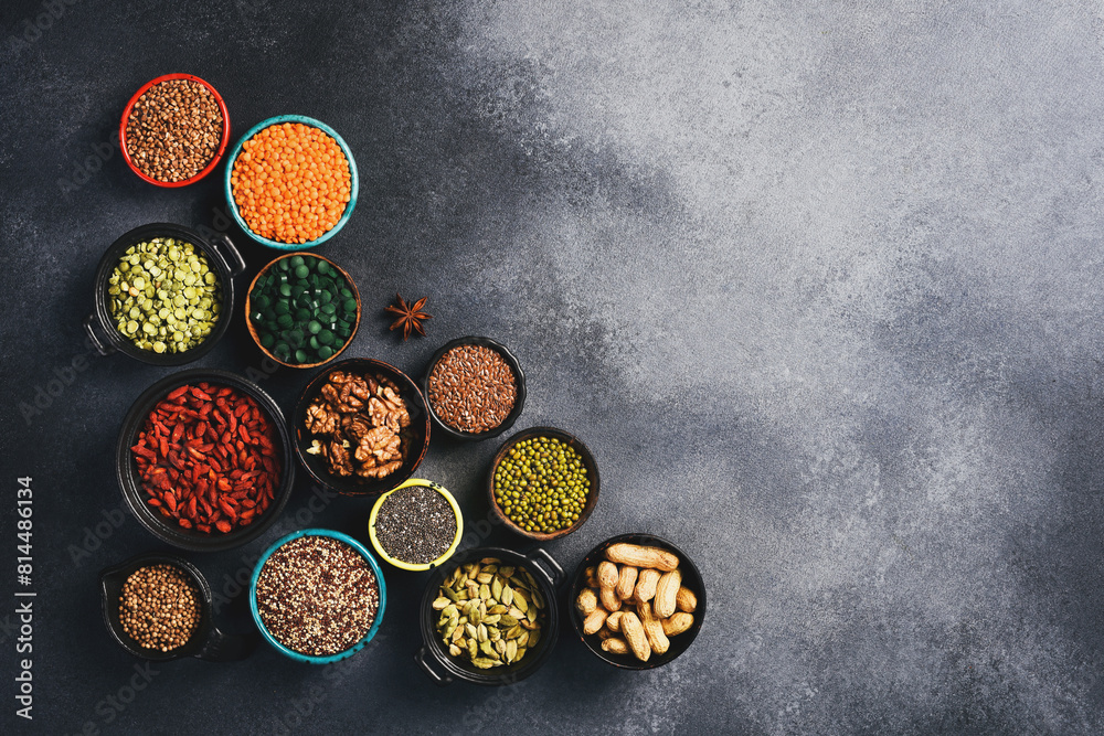 Banner with various superfoods in bowls on black stone background. Top view. Free space for text. Banner with various superfoods in bowls on black stone background. Top view. Free space for text.