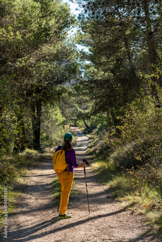 A woman standing in a clearing on an empty road in the woods of Costa Blanca, Alicante, Spain - stock photo