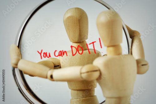 Wooden mannequin looking at himself in the mirror with the motivational message You can Do it! - Concept of self-reflection and positive affirmations for success and confidence photo