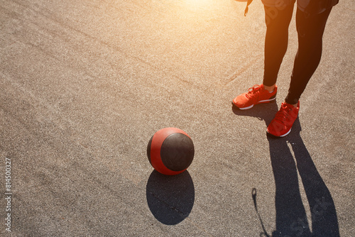 man in Electrical Muscular Stimulation stands near the ball on the street. free time, training for strength. closeup cropped photo