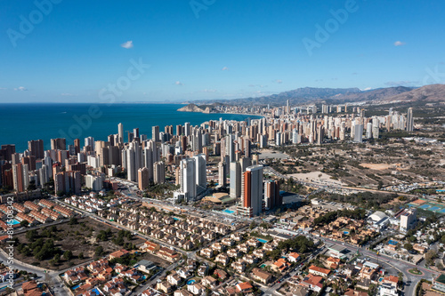 Aerial drone photo of the beautiful city of Benidorm in Spain in the summer time showing high rise apartments hotels and the main road leading to the beaches and ocean on a sunny day in the summer
