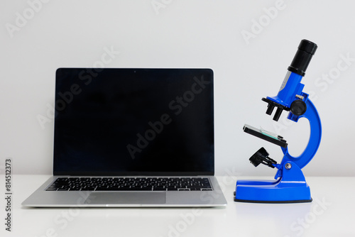Computer and  blue microscope on table