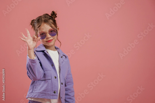 Fine hand gesture. Cute little girl is against pink background