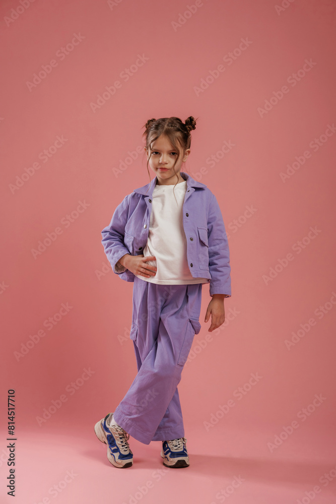 Standing and posing. Cute little girl is against pink background Standing and posing. Cute little girl is against pink background
