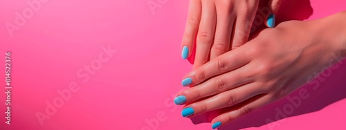 Female hands with perfect manicure in trendy neon light on pink background. Beauty concept.