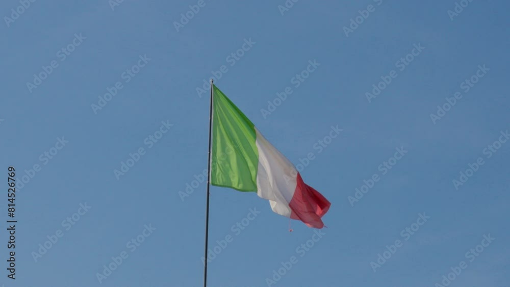 Italian flag waving against clear blue sky in Verona