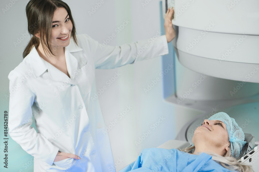 Naklejka premium Woman doctor and patient in the MRI room. female assistant preparing adult female patient for MRI scan 
