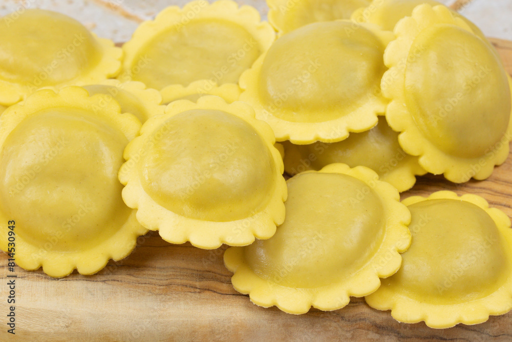 tas de raviolis crus, en gros plan, sur une planche à découper tas de raviolis crus, en gros plan, sur une planche à découper