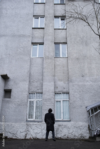 a serious man in a black coat on the street in Krasnoyarsk