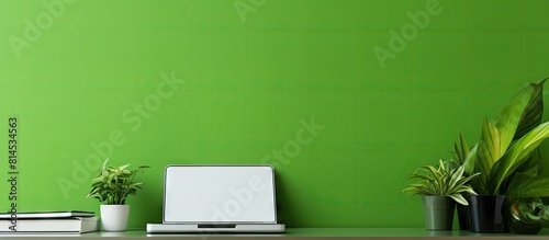 Copy space image of a home office workplace with a green wall and a chroma key computer screen on the desk © vxnaghiyev