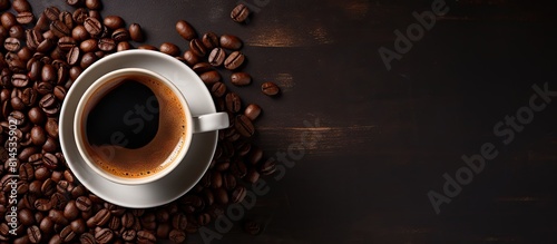 A top view image of a cup of black espresso for breakfast or evening refreshment with dark coffee beans as a background The concept represents morning energy and cheerfulness Copy space is available