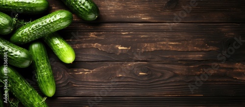 A top down view of fresh cucumbers displayed on a rustic wooden table providing ample space for text and creating a visually appealing copy space image