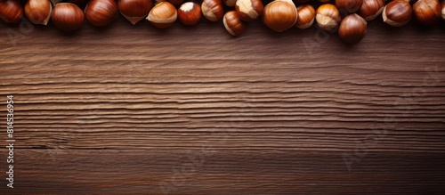 A wooden background with a close up image of hazelnuts and ample copy space