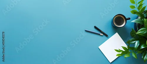 Panel kuchenny z motywem The copy space image shows a blue table background with a top view of an office desk It includes a notebook plastic plant smartphone and keyboard representing the concept of a creative designer