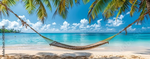 Sandy beach hammock swaying between palms with a backdrop of crystal waters and blue sky, inviting peacefulness photo