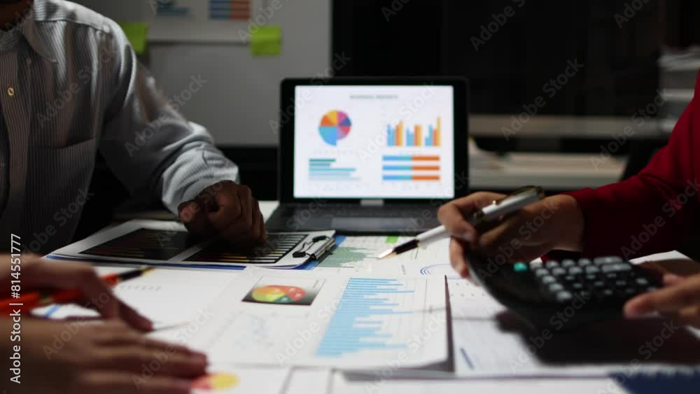 Businessman work overtime and meet with co-workers to discuss financial report analysis and market share situation to plan strategies. Discussion financial chart analysis to plan profit maximization. Businessman work overtime and meet with co-workers to discuss financial report analysis and market share situation to plan strategies. Discussion financial chart analysis to plan profit maximization.