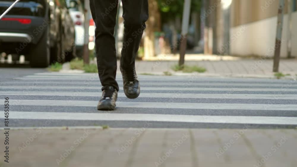 Blind man confidently crossing city street with cane on bright day Blind man confidently crossing city street with cane on bright day