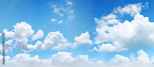 A bright and sunny day with clear blue skies scattered clouds and ample copy space image