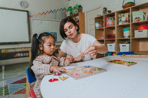 Girl and teacher playing with educational wooden toys in a kindergarten