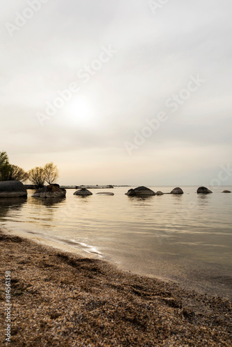 Rocky beach with boulders in the water under a cloudy sky