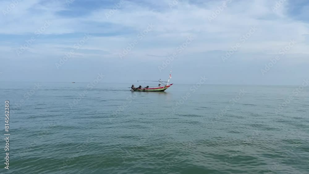 Fishing boats passing in the middle of the calm sea with a background of blue sky and clean sea
Fishing boats passing in the middle of the calm sea with a background of blue sky and clean sea