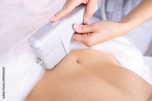 Portrait of relaxed young female client getting SMAS ultrasound face lifting massage