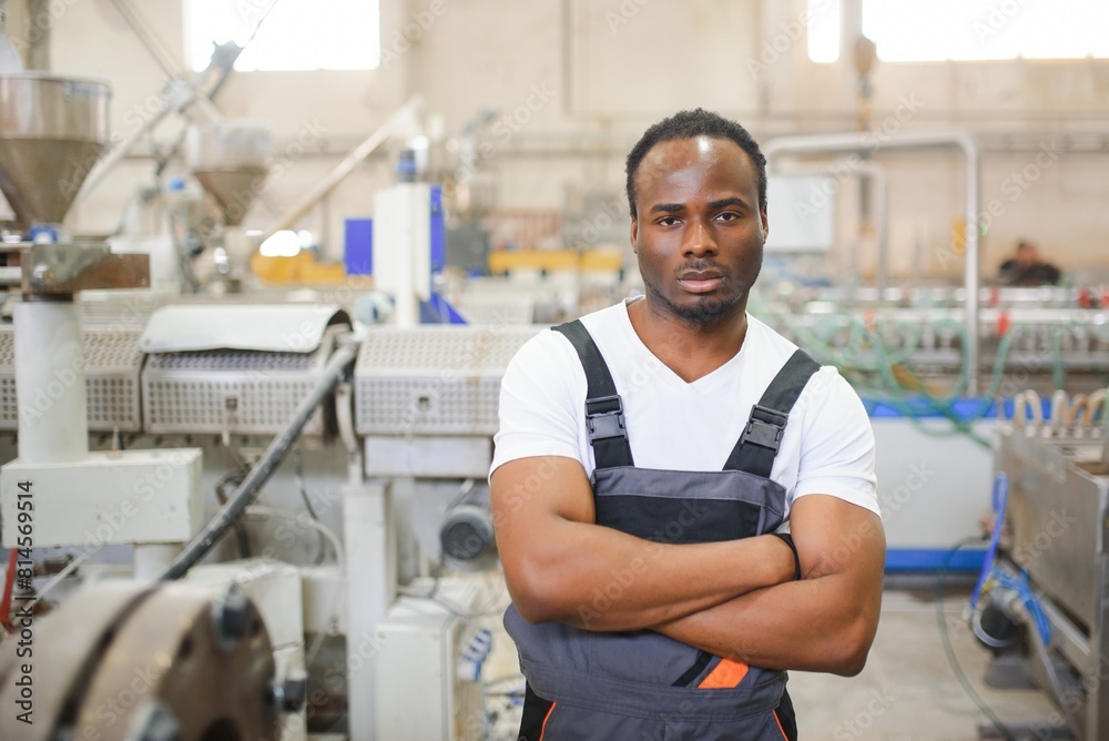 Portrait of African American male engineer in uniform and standing in industrial factory Portrait of African American male engineer in uniform and standing in industrial factory