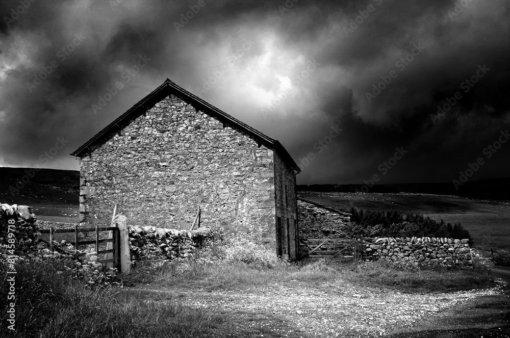 Black and white image of a old stone built farm house with stormy sky’s and dramatic lighting Black and white image of a old stone built farm house with stormy sky’s and dramatic lighting