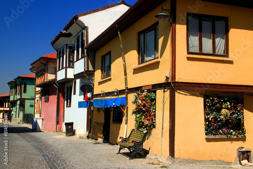 Street view with colorful old houses and a bench in the foreground against the clear blue sky in the historical part of the city of Eskisehir in Turkey