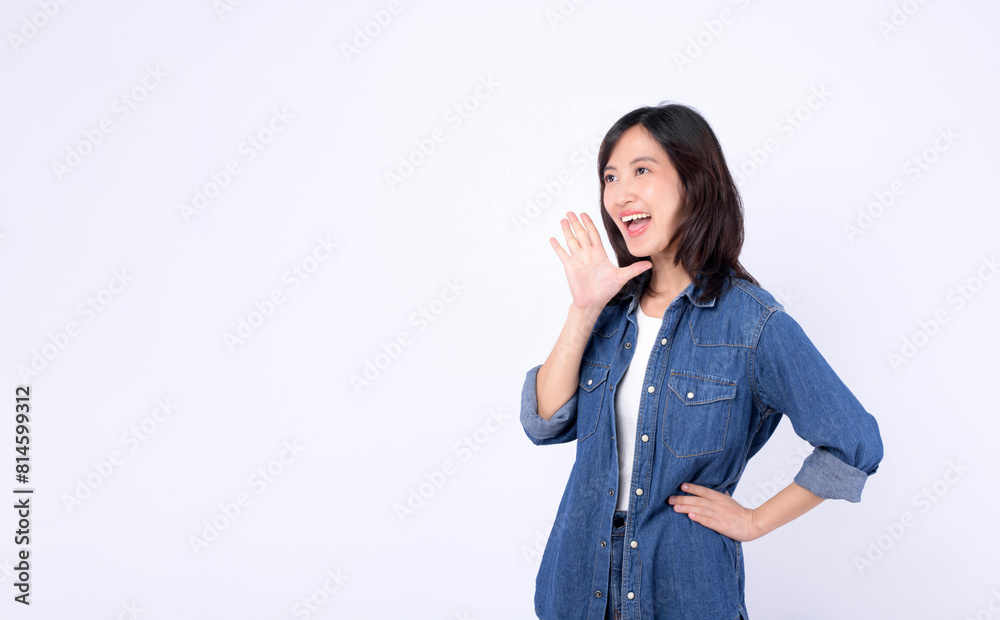 Asian woman wearing denim jean is posing with a shouting gesture against a white background. Asian woman wearing denim jean is posing with a shouting gesture against a white background.