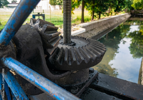 a large gear mechanism used to create or close the flow of irrigation river water
 photo