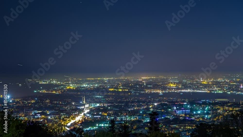 Istanbul night skyline scenery day to night transition timelapse, aerial view over Bosporus channel from Camlica hill. Blue water of Bosporus channel with ship. Traffic on roads photo