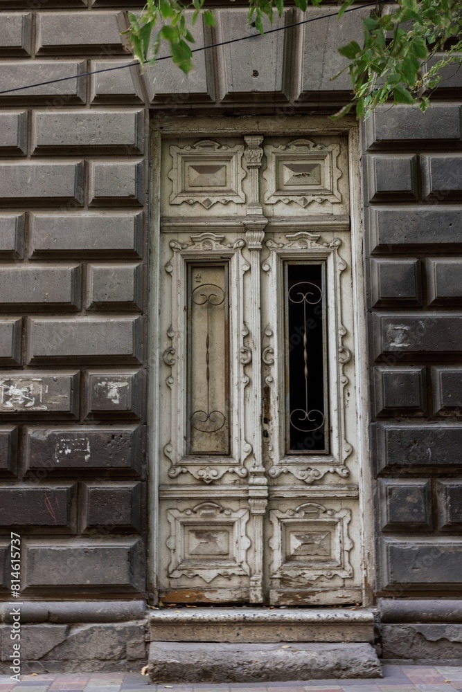 Ancient wooden door standing in contrast to the modern Armenian architecture of the surroundings Ancient wooden door standing in contrast to the modern Armenian architecture of the surroundings