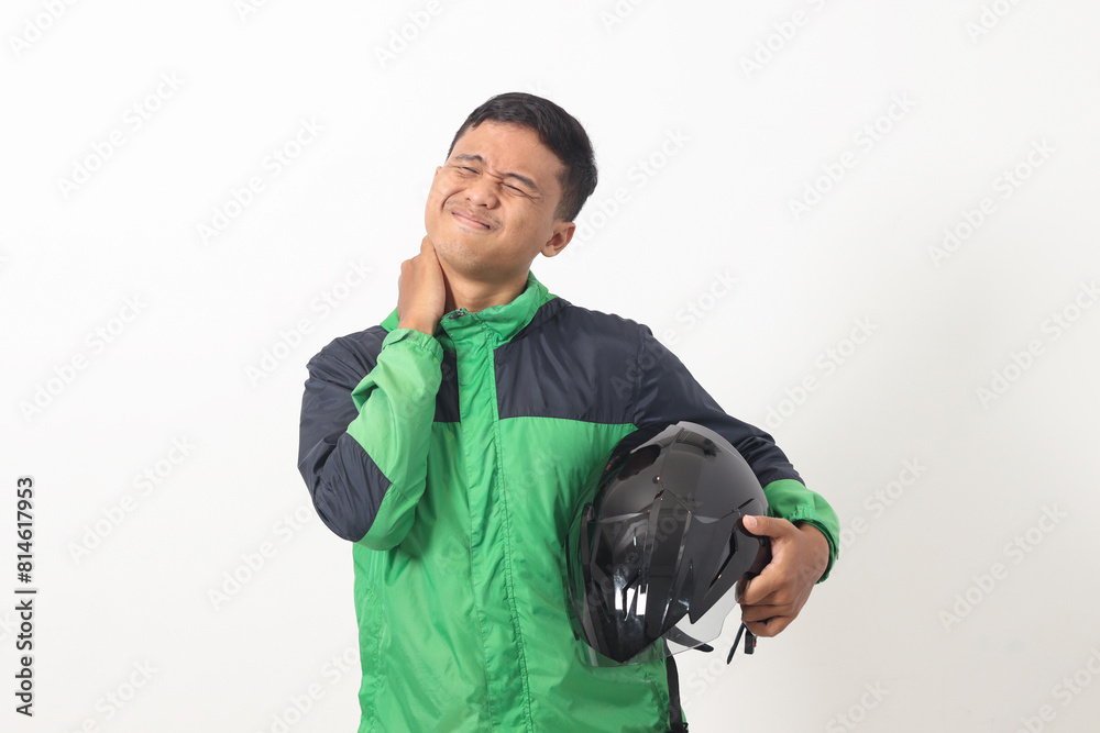 Portrait of tired Asian online taxi driver wearing green jacket holding a helmet on hip and feeling exhausted. Isolated image on white background Portrait of tired Asian online taxi driver wearing green jacket holding a helmet on hip and feeling exhausted. Isolated image on white background