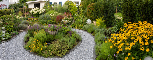 Panoramic garden view with a variety of flowers, herbs and bushes