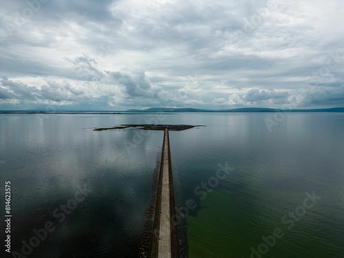 Foto Aerial view of Mutton Island and causeway in Galway,IE under a bright sky