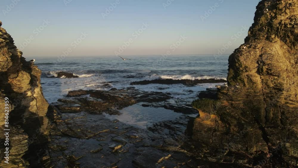 Ascending drone shot of the ocean waves crashing on the rocks of Punta de Lobos in Pichilemu, Chile Ascending drone shot of the ocean waves crashing on the rocks of Punta de Lobos in Pichilemu, Chile