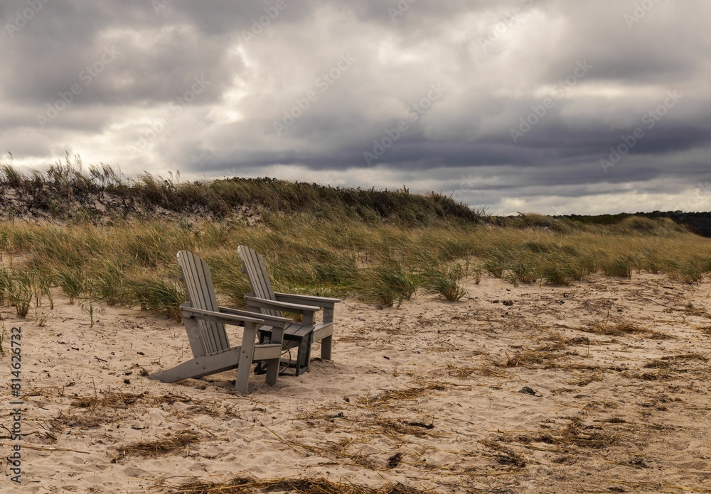 Scenic view of two wooden chairs on a beach on Cape cod Scenic view of two wooden chairs on a beach on Cape cod