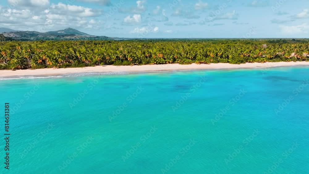 View from the sea of the beautiful tropical beach of the Dominican Republic. Landscape of a paradise beach with vibrant nature and turquoise ocean. Palm jungle against a cloudy sky. View from the sea of the beautiful tropical beach of the Dominican Republic. Landscape of a paradise beach with vibrant nature and turquoise ocean. Palm jungle against a cloudy sky.