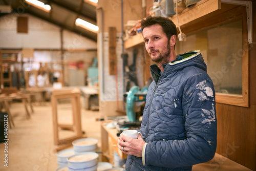 Carpenter Working In Woodwork Workshop On Coffee Break