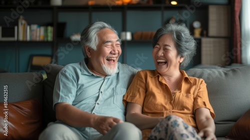Wallpaper Mural Elderly Asian couple sharing a joyful moment together on a sofa, reflecting happiness and bonding, ideal for Senior's Day or family themes. Torontodigital.ca