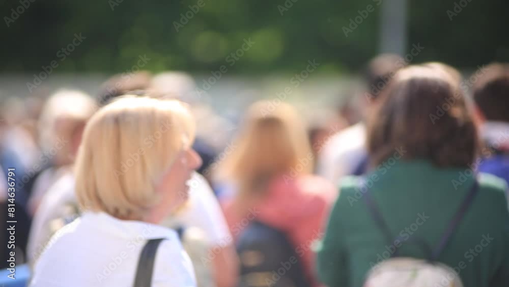 persone in coda che camminano in attesa di entraread un evento ,fiera ,ripresa di spalle 
