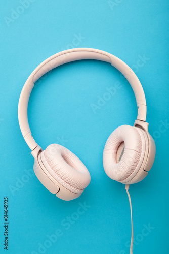 Pink headphones on blue background. Vertical photo