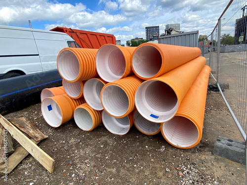 Orange cable protection pipe systems before installation. Urban engineering concept. Mobile phone photo