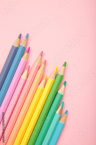 Pastel color pencils on pink background. Vertical photo