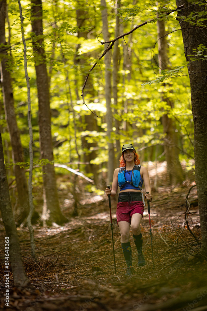 A woman is walking through a forest with a backpack on A woman is walking through a forest with a backpack on